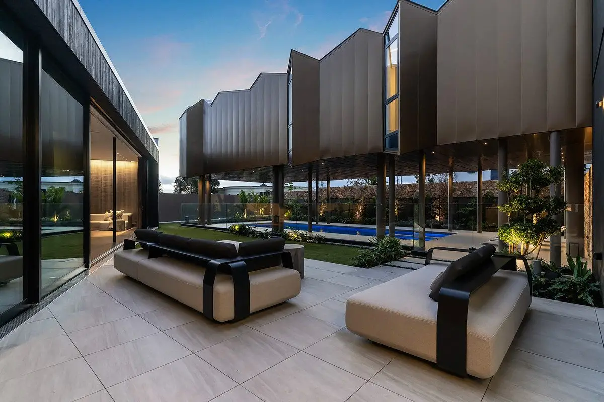 Exterior of architecural house on a sunny day in Christchurch, includes pavers, swimming pool, feature facade cladding and a Quantity Surveyor in Christchurch